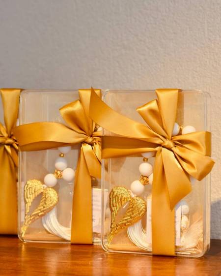 Μπομπονιέρα γάμου ή βάπτισης γούρι απο λευκές ματ και χρυσές χάντρες και μεταλλικά χρυσά φτερά αγγέλου και λευκή φούντα